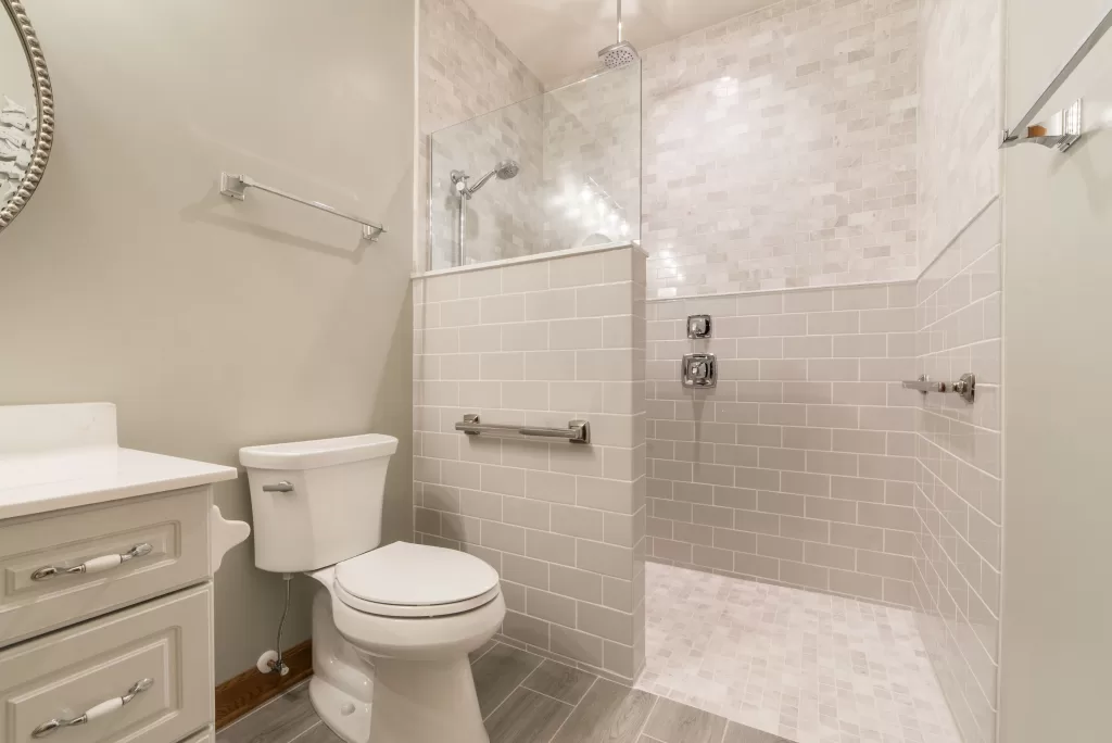 beautiful guest bathroom with white tile and ADA bars