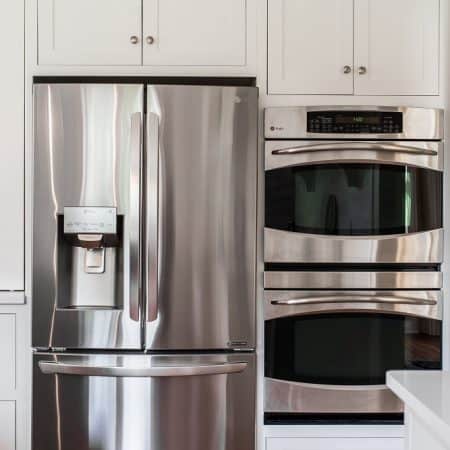 stainless steel appliances in white kitchen