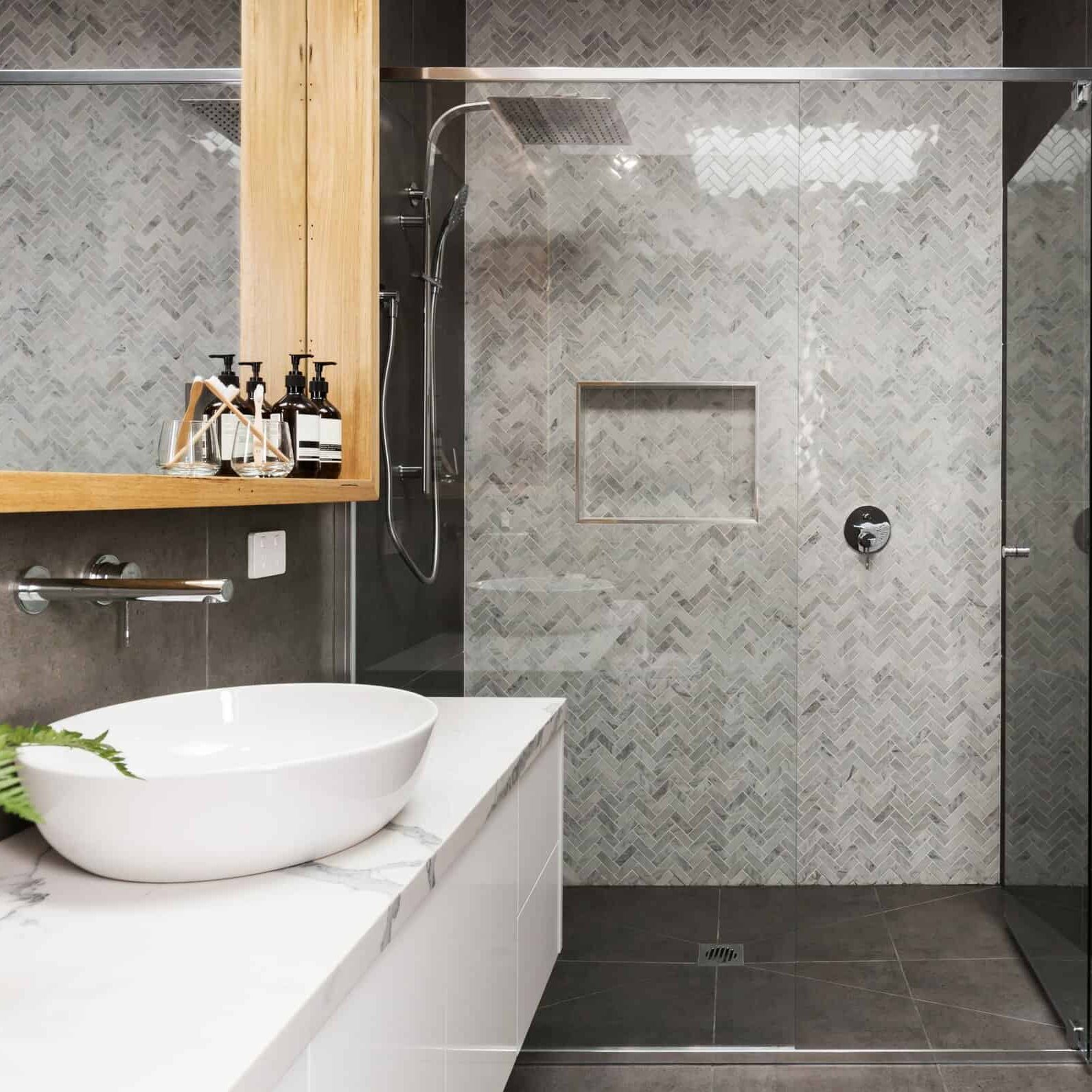 Marble mosaic herringbone tiled shower feature wall in a contemporary ensuite bathroom